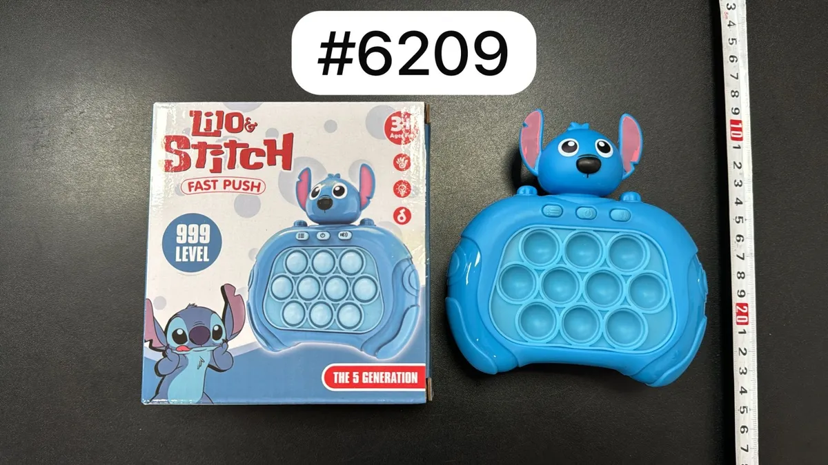 niebieska gra sensoryczna Lilo & Stitch z 12 bąbelkami i figurką Stitcha obok opakowania