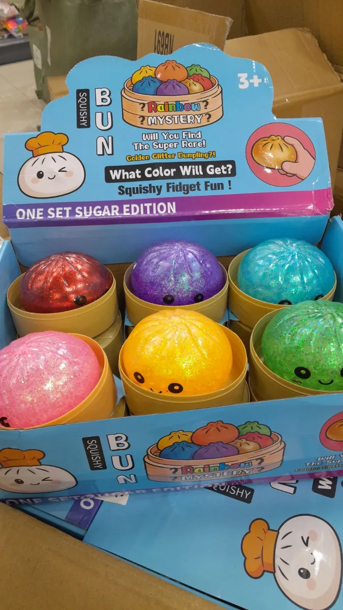 Kolorowe brokatowe squishy w kształcie bułeczek w opakowaniu z napisem Rainbow Mystery