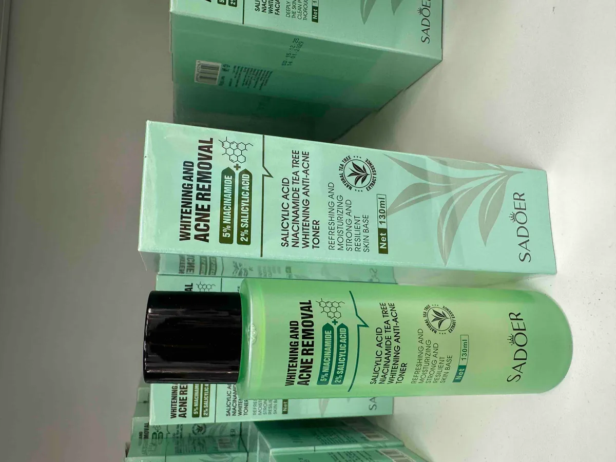 Butelka jasnej zieleni z czarną zakrętką i kartonowe opakowanie toniku SADOER 130 ml