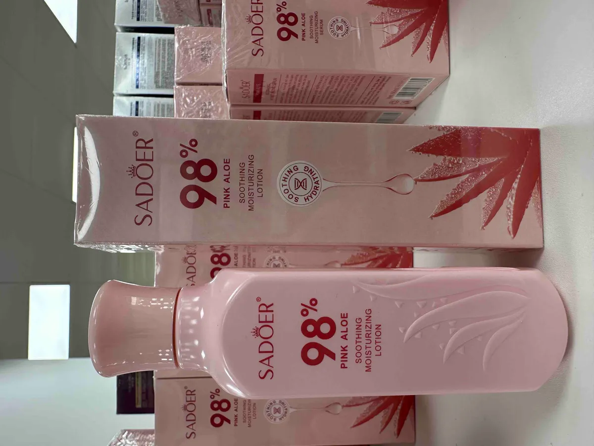 Różowy flakon balsamu SADOER 98% Pink Aloe z kartonowym opakowaniem i grafiką liścia aloesu