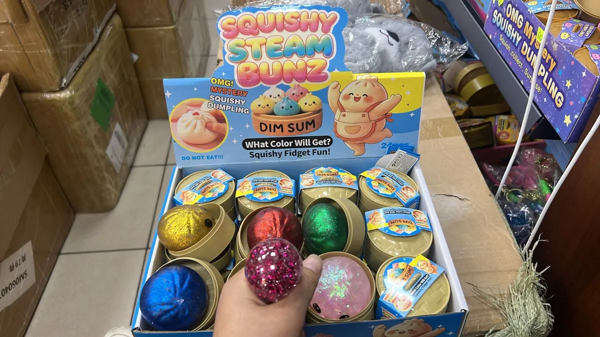 Metaliczne kolorowe piłeczki squishy w kształcie bułeczek dim sum w złotych pudełkach na półce sklepowej