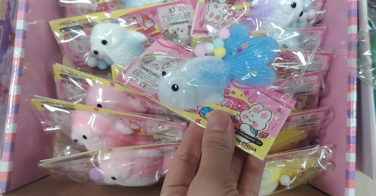 miękka ryba squishy z niebieskim ogonem i kolorowymi kulkami w przezroczystym opakowaniu