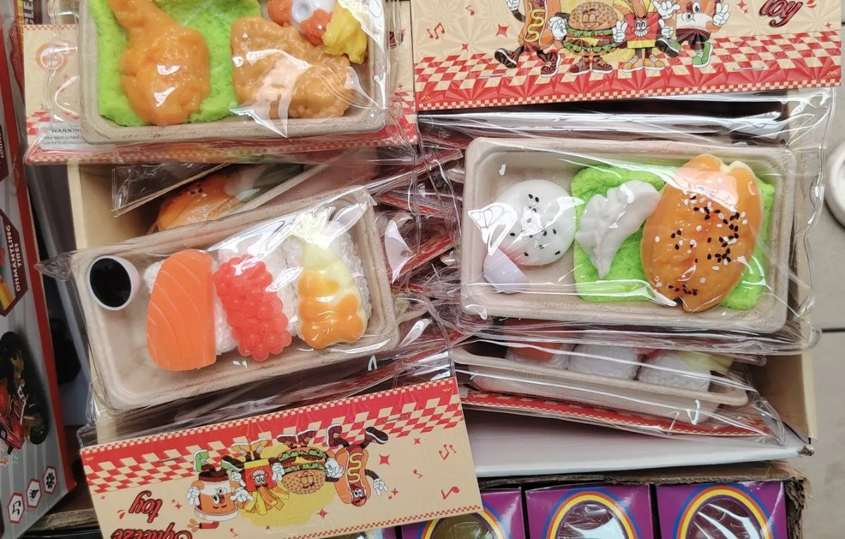 zestaw miniaturowych sztucznych potraw sushi i kurczaka na zielonej podkładce w przezroczystym opakowaniu
