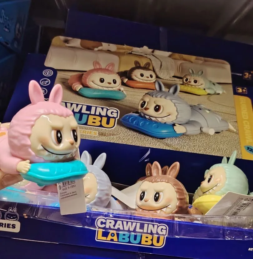 kolorowe figurki Crawling Labubu z dużymi oczami i uszami, trzymające niebieskie i żółte poduszki
