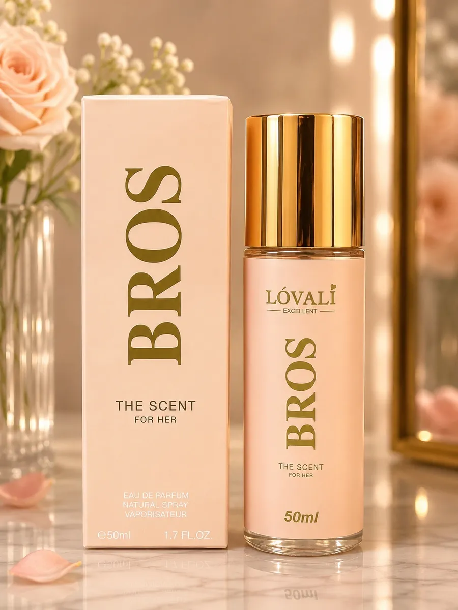Różowy flakon perfum Bros The Scent For Her 50ml z złotym kapslem obok pudełka na marmurowym blacie z różami