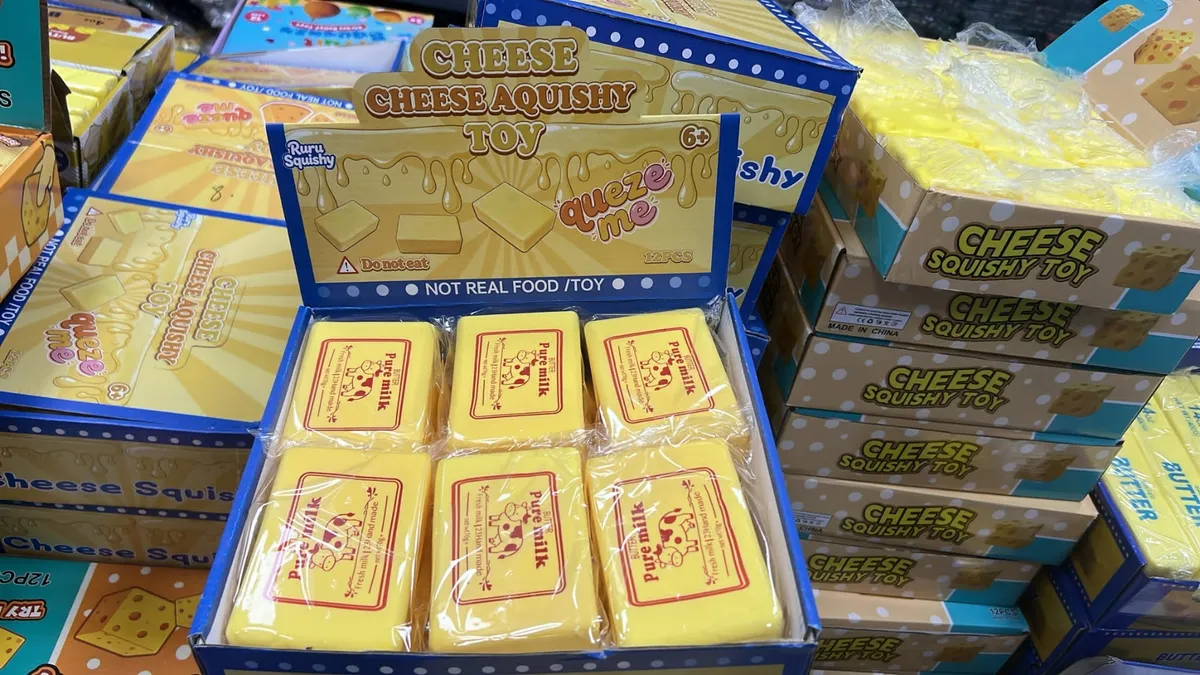 Żółte kostki sera squishy toy w kartonowym displayu z nadrukiem Pure Milk i Cheese Aquishy Toy