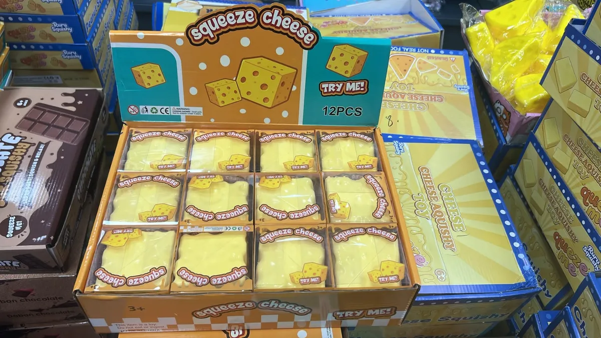 Karton zbiorczy z 12 sztukami żółtych zabawek Squeeze Cheese w kształcie sera, zapakowanych w przezroczyste folie