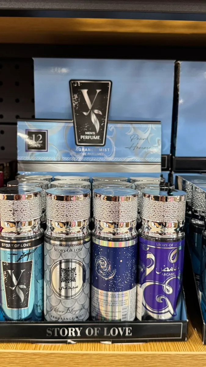 Cztery butelki body mist Story of Love w różnych wariantach kolorystycznych z błyszczącymi srebrnymi nakrętkami na półce skle