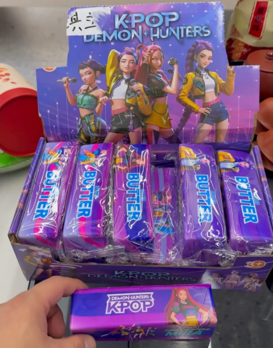 Display z gumkami do mazania K-Pop Demon Hunters Butter w fioletowych opakowaniach z postaciami Mira i innymi bohaterkami