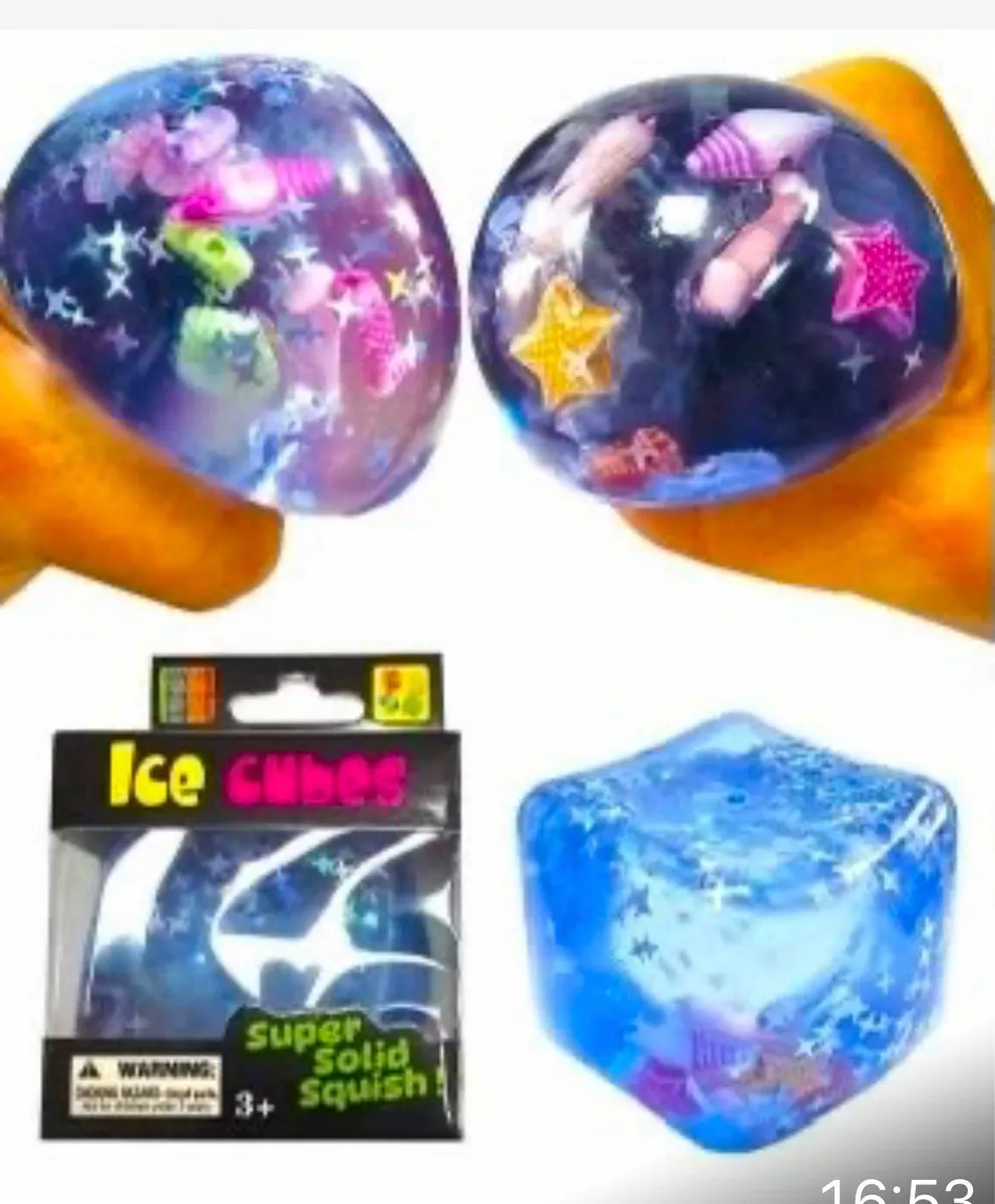 Przezroczysta niebieska kostka lodu Ice Cubes wypełniona muszelkami, gwiazdami morskimi i brokatem, obok opakowania blister