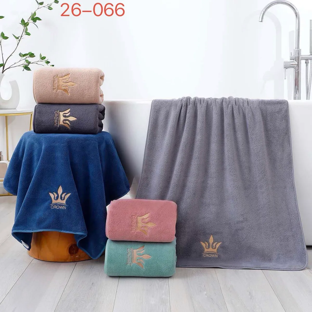 Ręczniki z mikrofibry Crown w kolorach granatowym, szarym, pudrowym różu, miętowym i beżowym z złotym haftem korony, ułożone