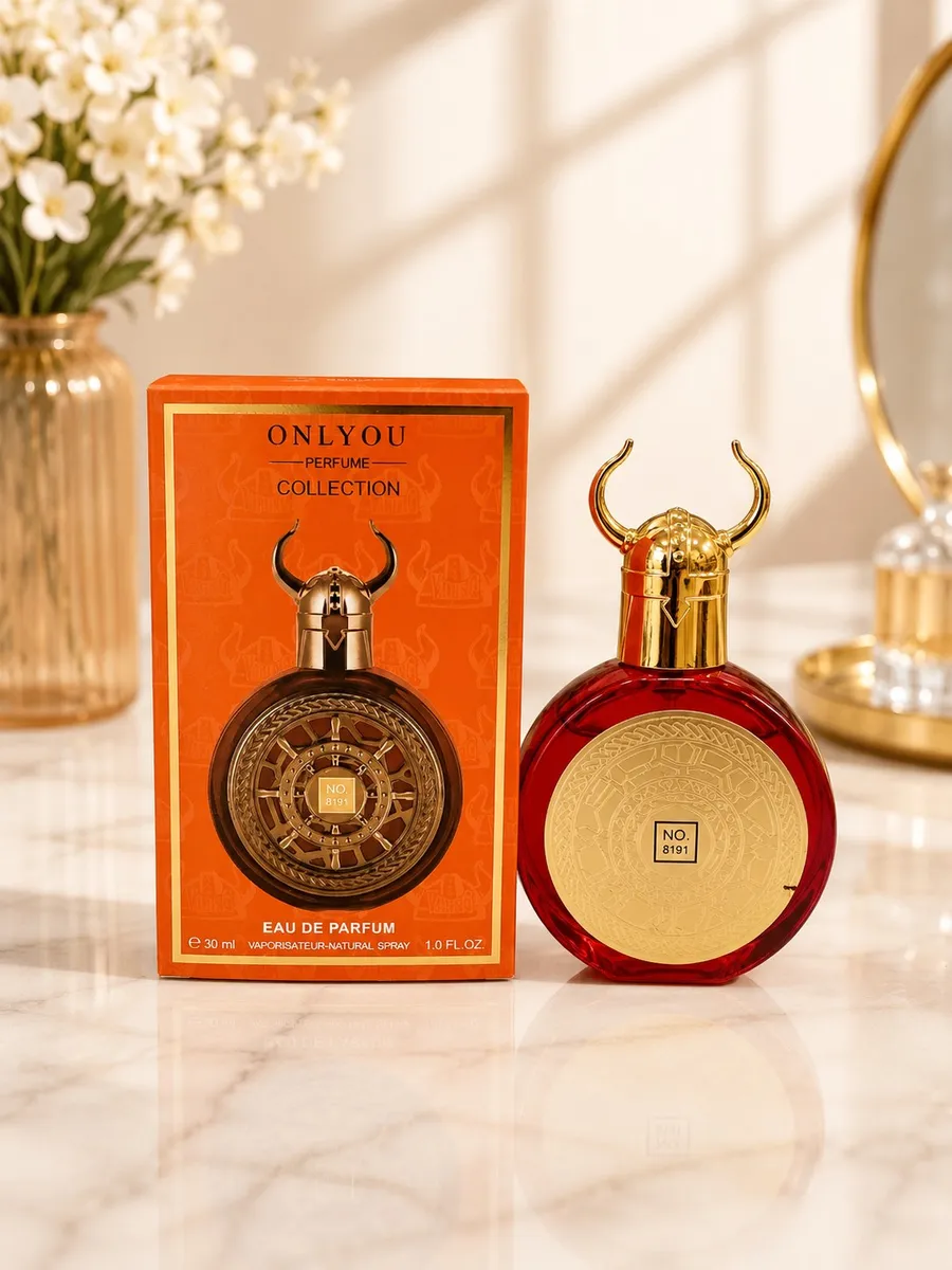 Czerwony flakon perfum Only You No. 8191 z złotym hełmem wikinga obok pomarańczowego pudełka na marmurowym blacie