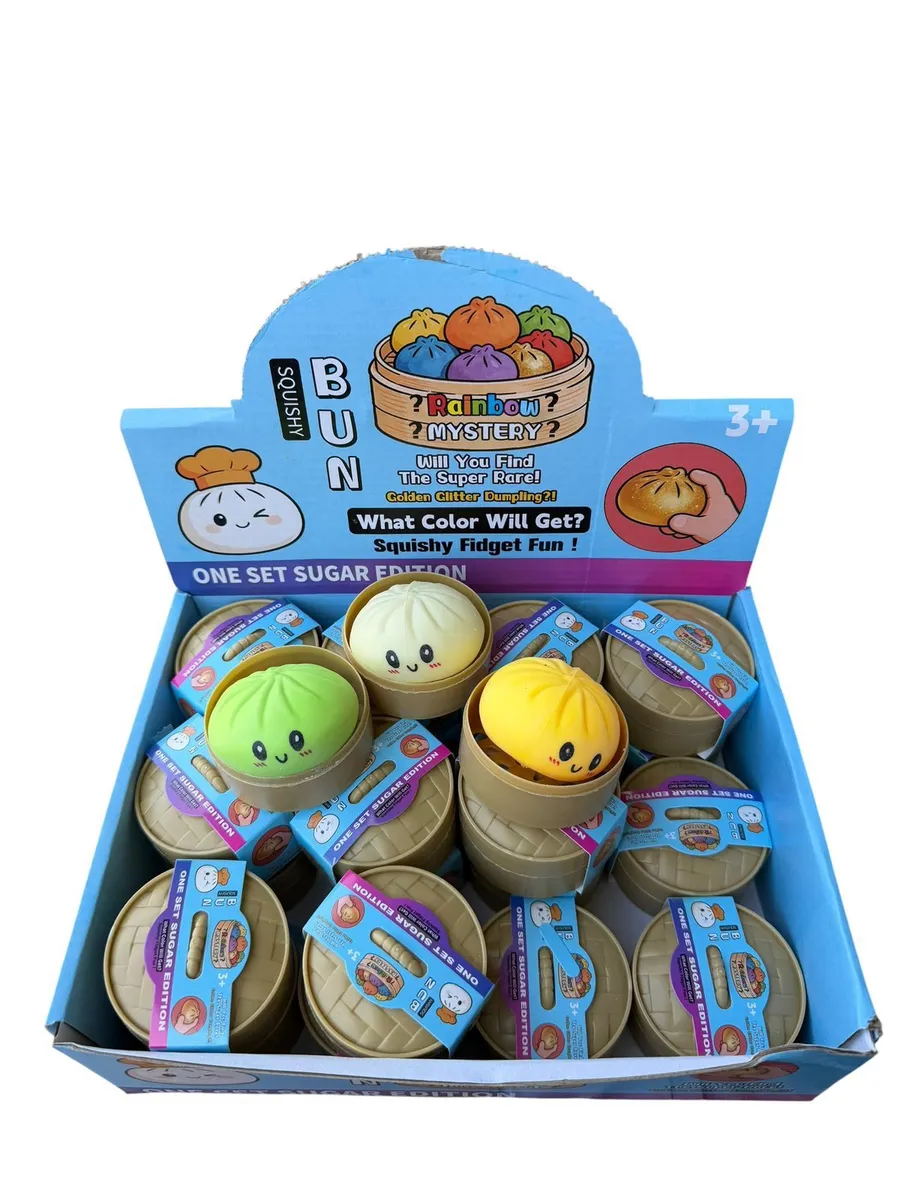 Zestaw squishy buns w bambusowych koszyczkach w niebieskim displayu, widoczne zielony, żółty i biały pierożek z buźkami, opak
