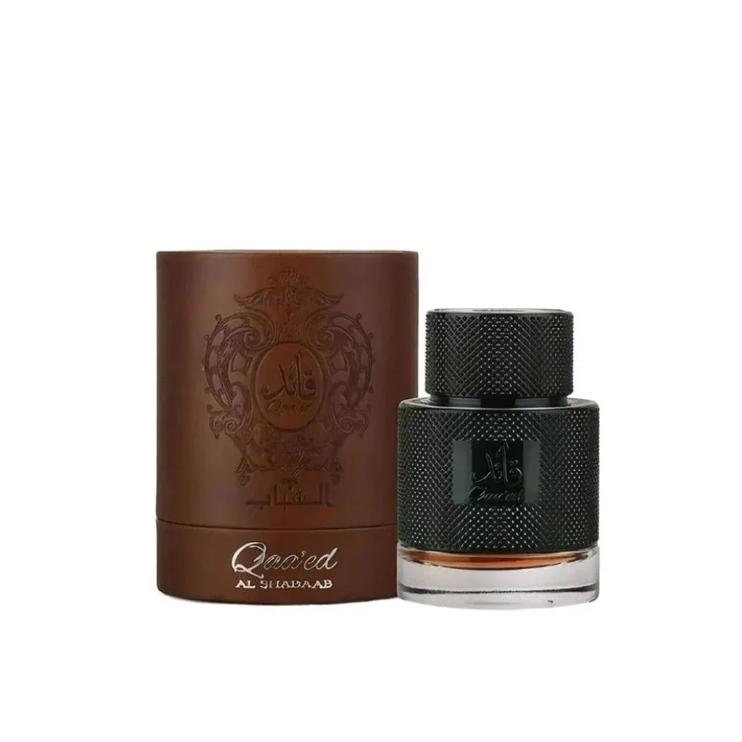Elegancki flakon perfum Qaa'ed Al Shujaa 100ml z ciemnozieloną teksturowaną nakładką obok brązowego kartonowego pudełka z orn