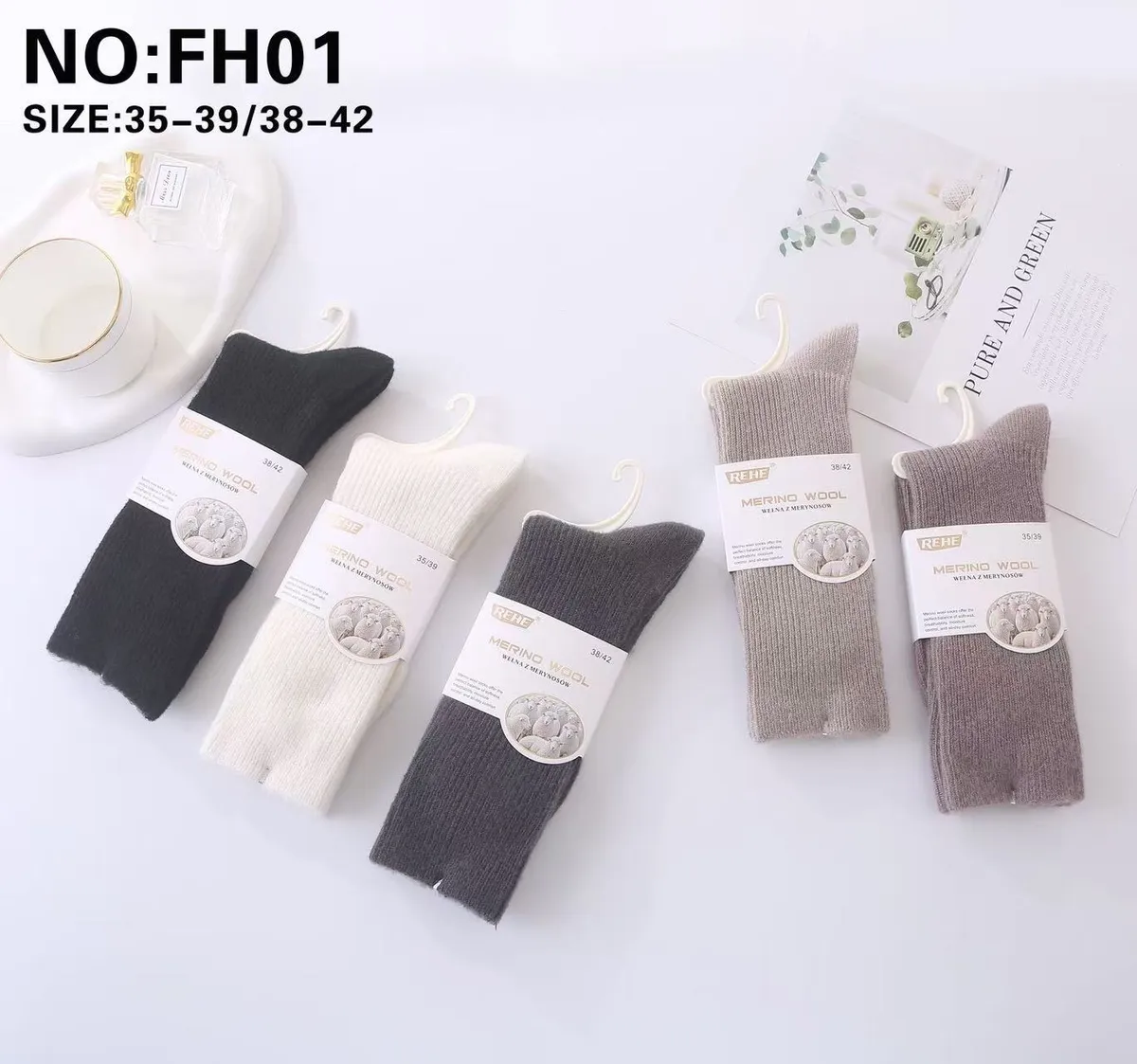 Cztery pary skarpet wełnianych REHE Merino Wool w kolorach czarnym, białym, szarym i beżowym na białym tle z opakowaniami i w