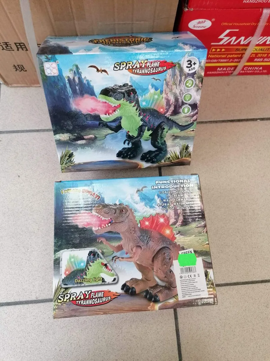 Dwa kartonowe opakowania zabawki Spray Flame Tyrannosaurus Rex z ilustracjami dinozaura sikającego różową mgiełką wody