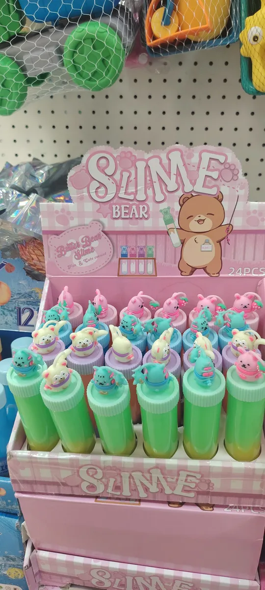 Kolorowe tuby slime z pastelowymi figurkami zwierząt na zakrętkach w różowym opakowaniu zbiorczym