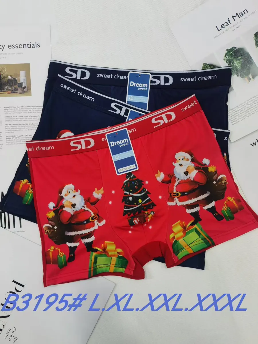 Trzy bokserki męskie, dwie granatowe i jedna czerwona z nadrukiem świątecznego Mikołaja i choinki