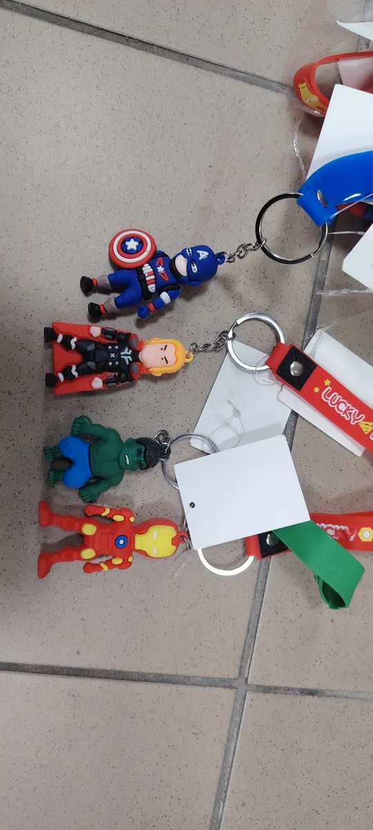 Breloki z czterema postaciami superbohaterów na metalowych kółkach z kolorowymi paskami