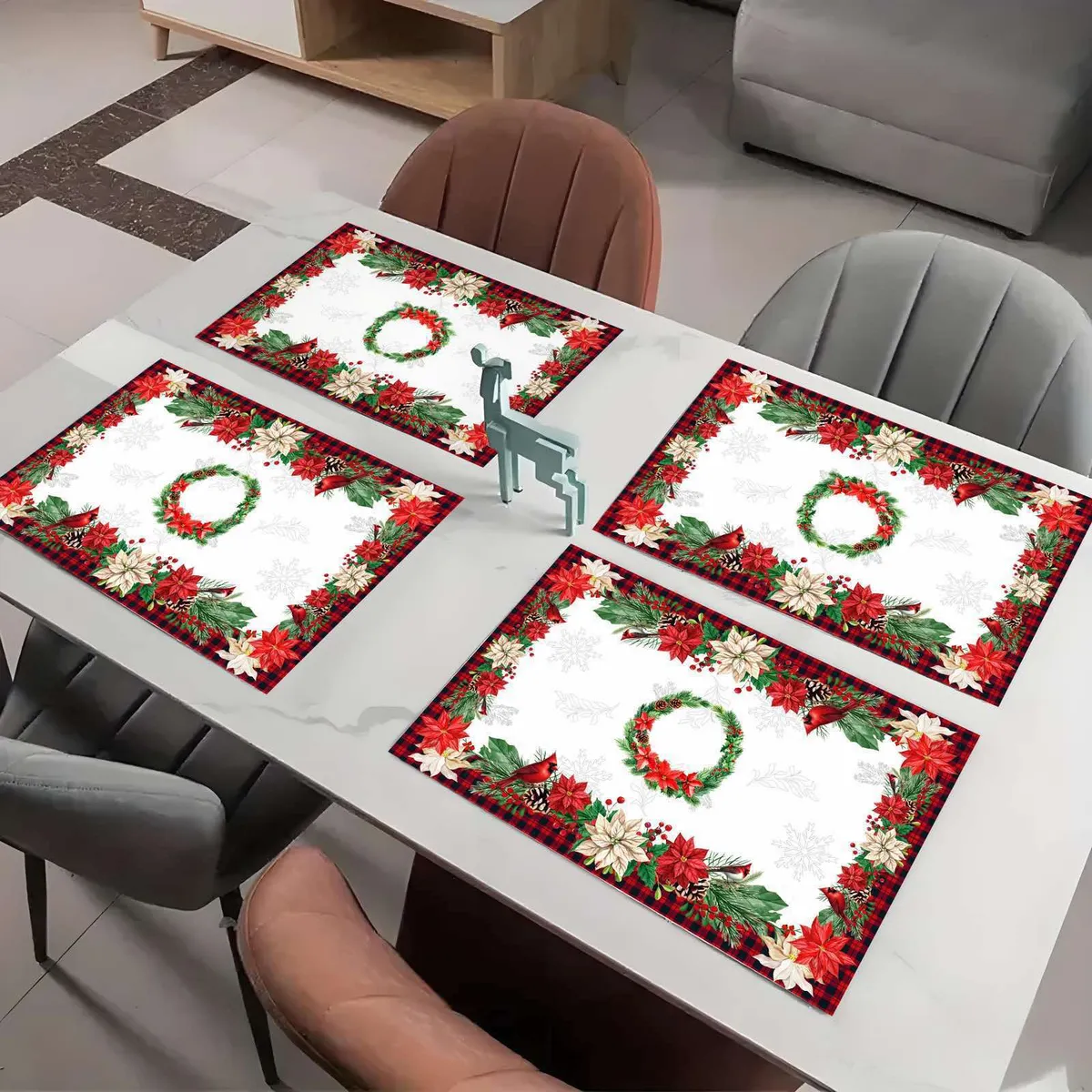 Cztery świąteczne serwetki 30x45 cm z czerwonym i białym wzorem gwiazdy betlejemskiej i zielonym wieńcem na stole