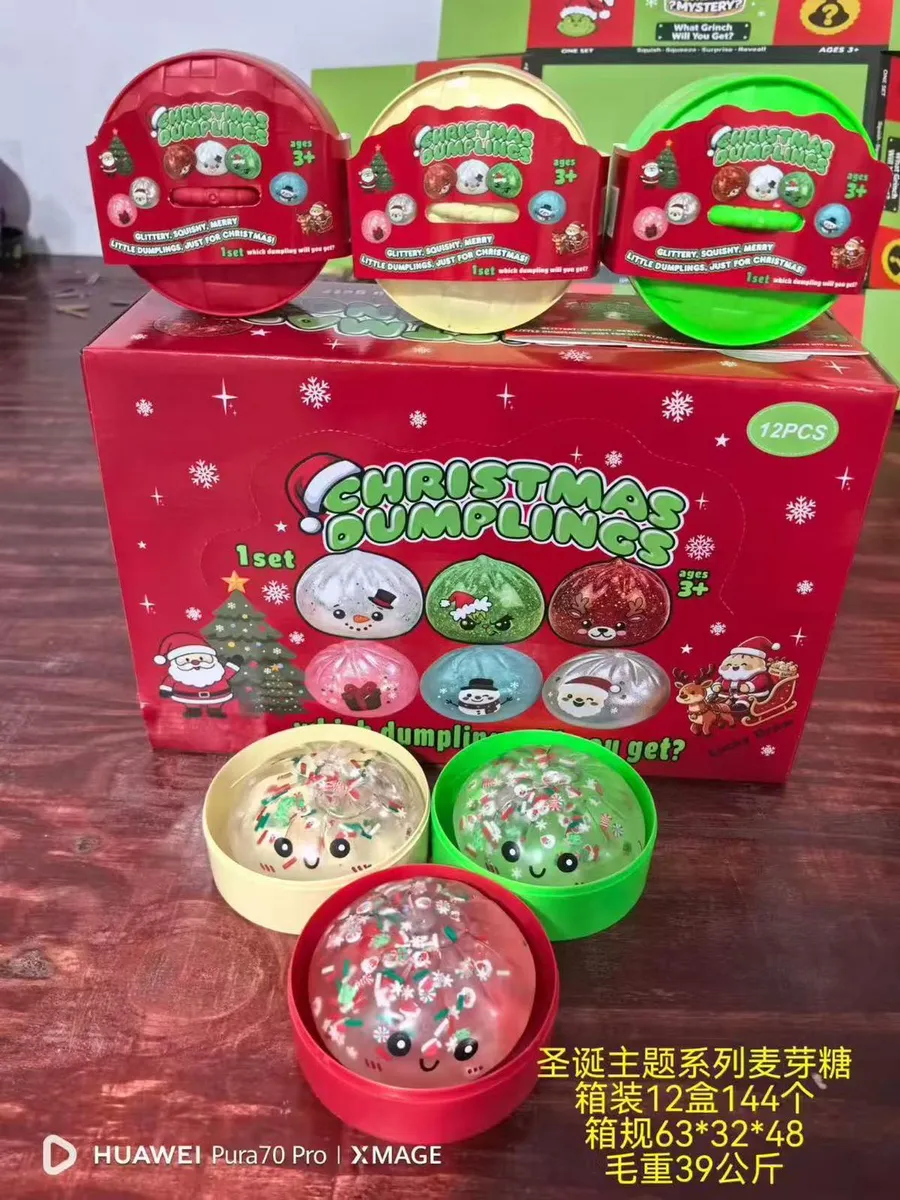 zestaw trzech świątecznych squishy w czerwonym, zielonym i złotym pojemniku na tle pudełka z motywem bożonarodzeniowym