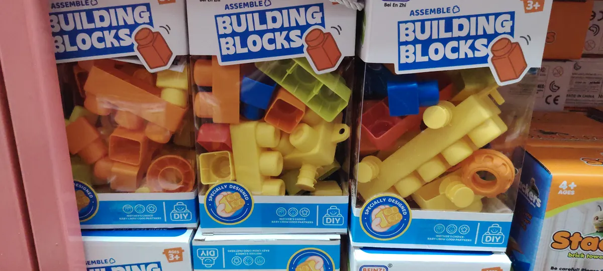 Zestaw klocków budowlanych w kolorach żółtym i pomarańczowym w przezroczystym opakowaniu z napisem Building Blocks