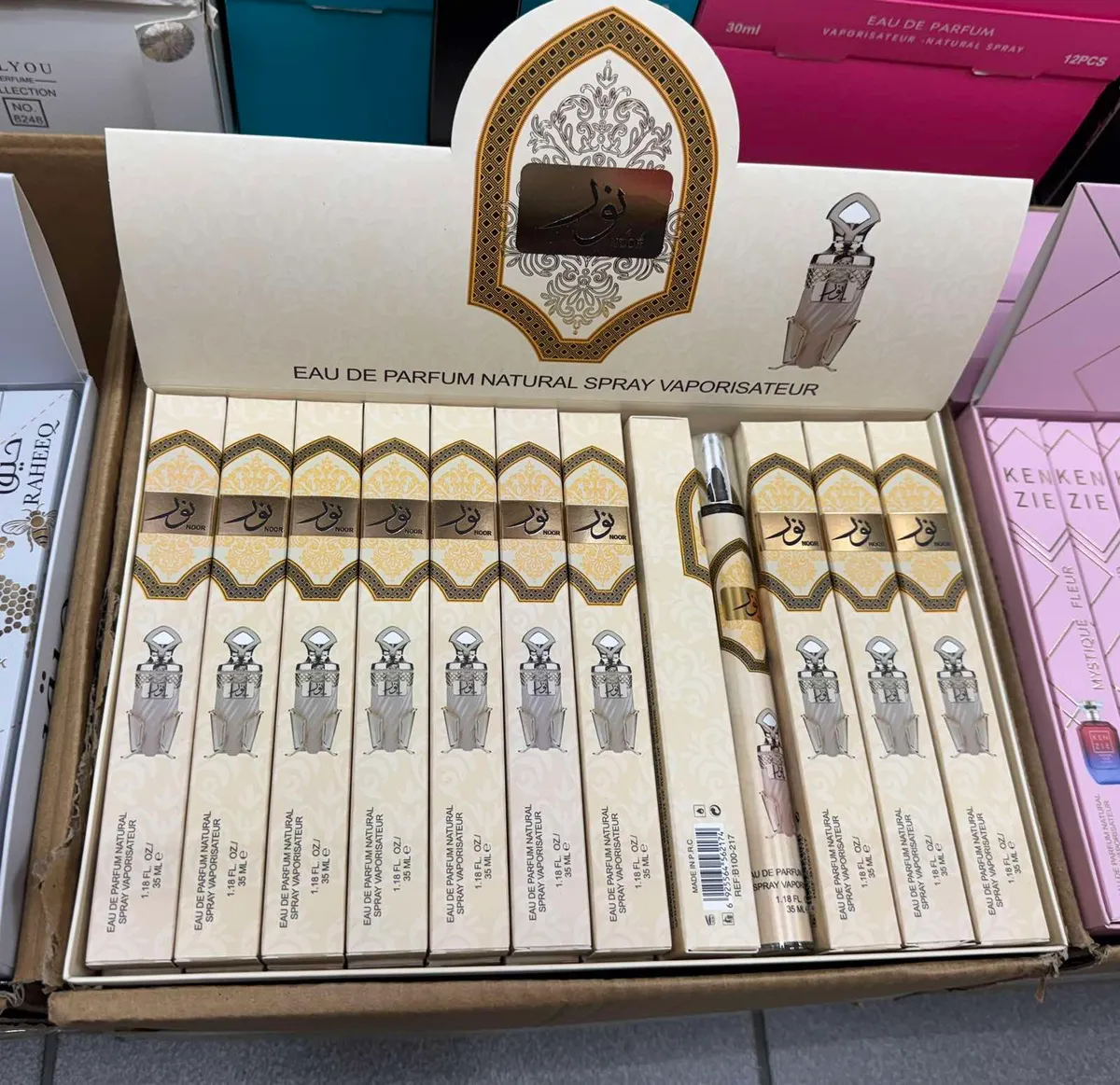 Kremowe opakowania perfum NOOR 35 ml w kartonie zbiorczym z dekoracyjnym złoto-brązowym wzorem