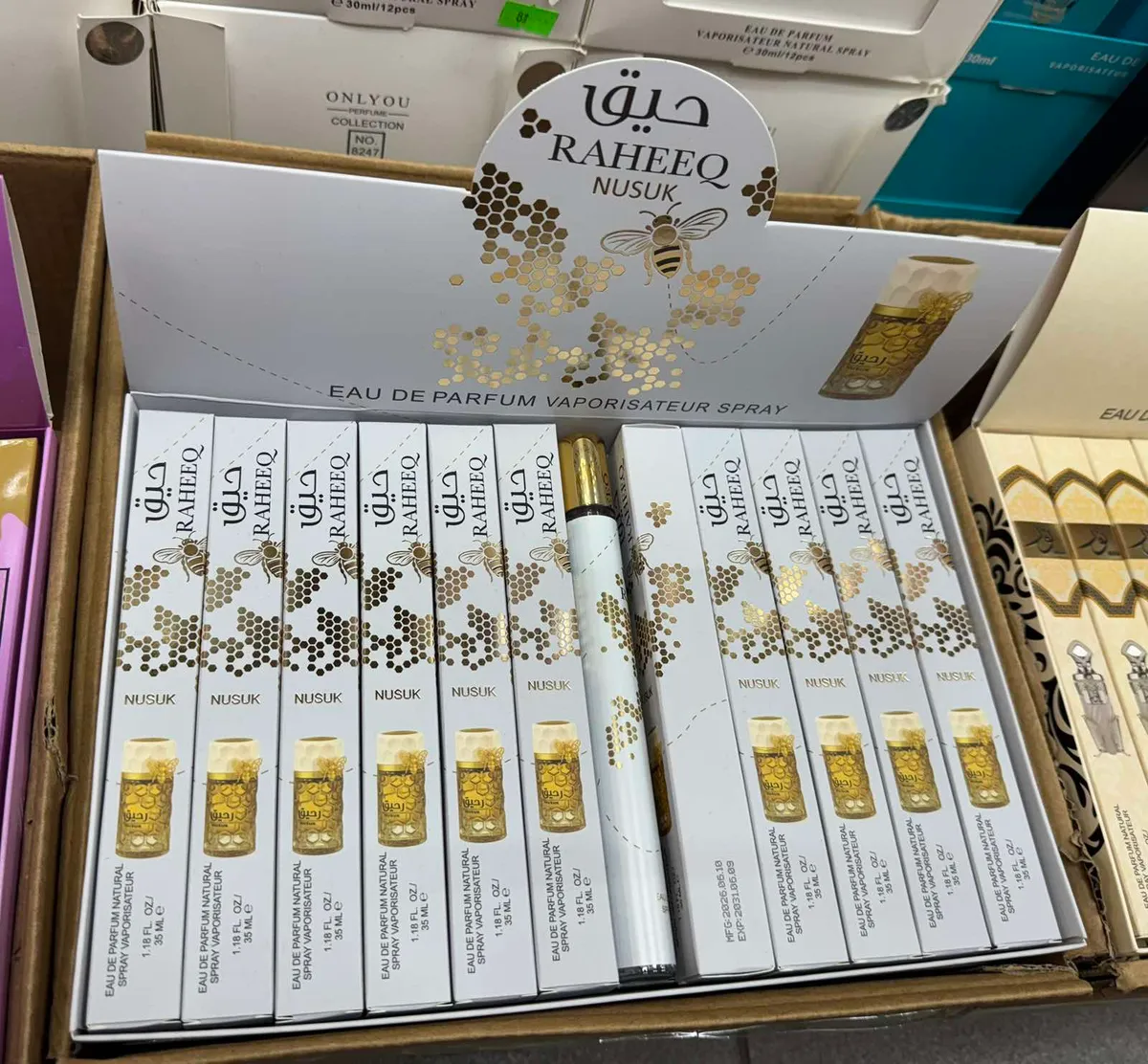 Perfumy Raheeq Nusuk 35 ml w białym opakowaniu z motywem złotych plastrów miodu i pszczoły
