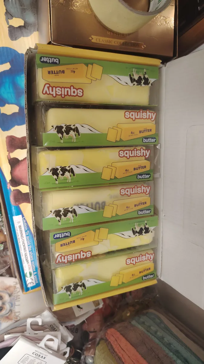 Zestaw miękkich zabawek squishy w kształcie kostki masła z grafiką krowy w opakowaniu