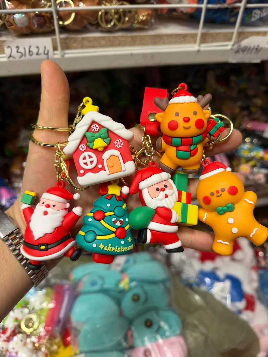 kolorowe breloki świąteczne z Mikołajem, reniferem, choinką, piernikiem i domkiem na tle sklepowych półek