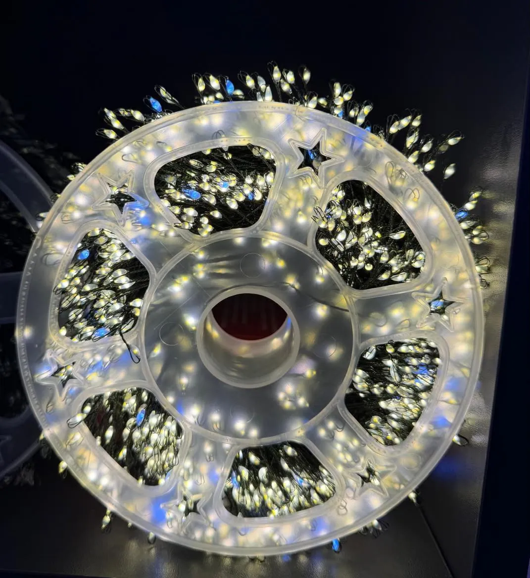 Zwinięte lampki choinkowe LED na białym plastikowym bębnie z gwiazdkami, świecące ciepłym białym i białym migającym światłem