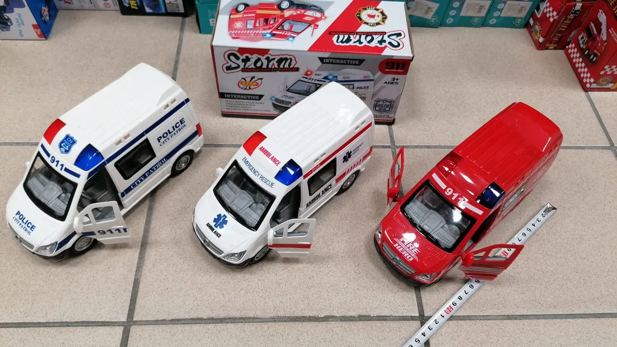 Trzy metalowe samochody służb ratunkowych: biały radiowóz, biały ambulans i czerwony wóz strażacki