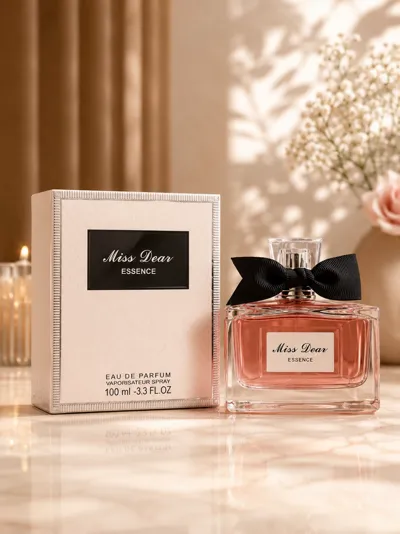 Flakon perfum Miss Dear Essence 100ml z różowym płynem i czarną kokardą obok kremowego pudełka