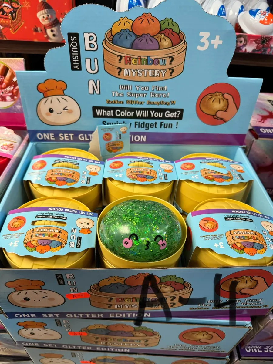 Zestaw squishy bun rainbow mystery z brokatem w żółtych pojemnikach, zielona brokatowa kulka na środku