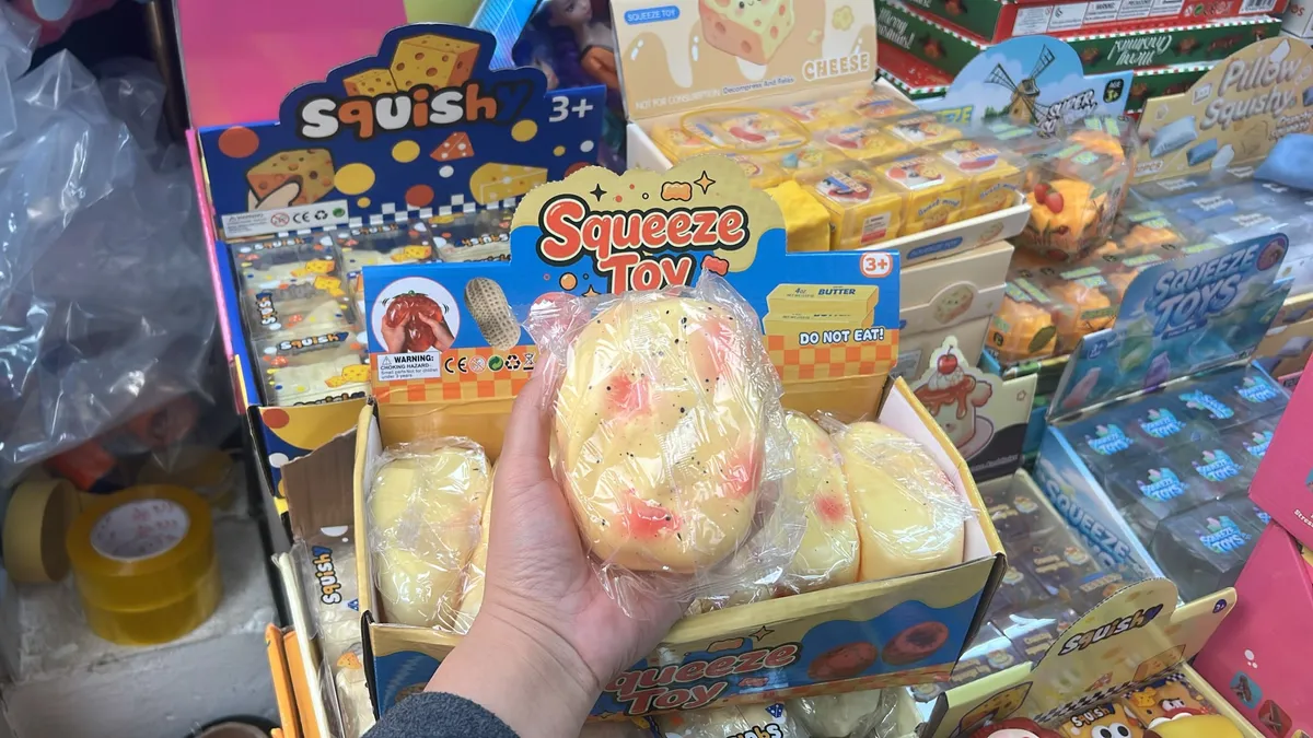 Miękka piankowa zabawka squishy w kształcie kromki chleba z masłem, żółta z czerwonymi i czarnymi detalami
