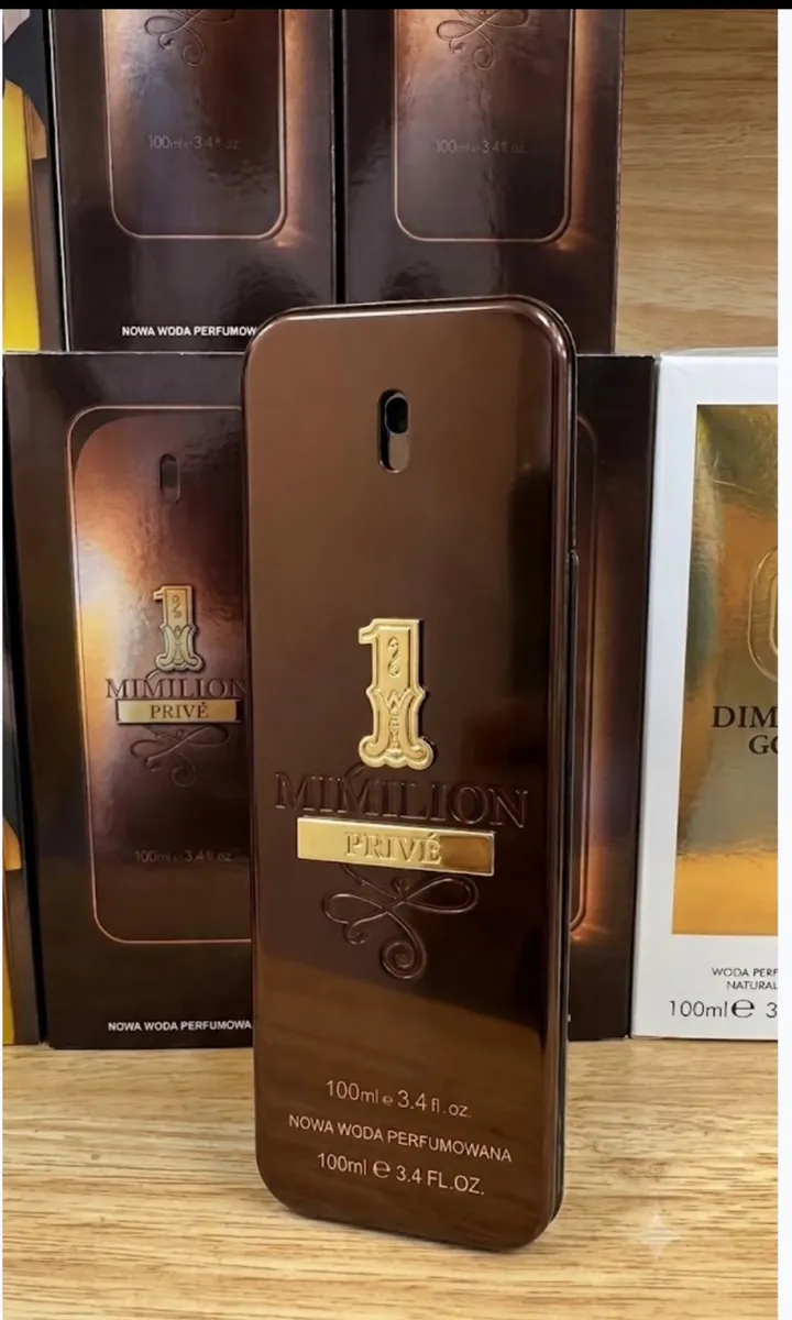 Brązowy metaliczny flakon perfum 1 Million Privé 100 ml na tle kartonów opakowań