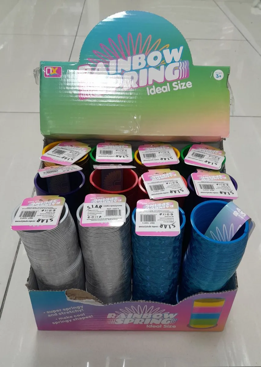 Kolorowe sprężyny tęczowe rainbow spring w opakowaniu zbiorczym na białej podłodze