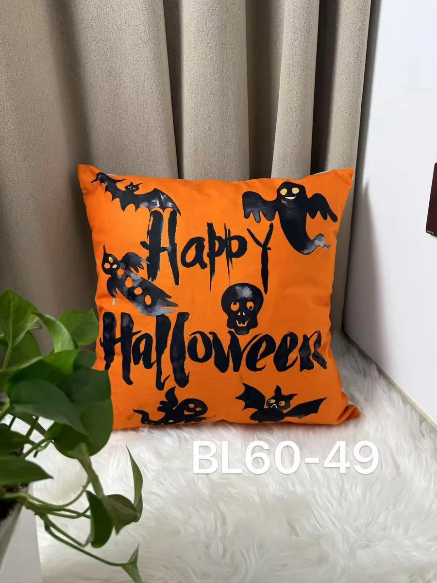 Pomarańczowa poszewka na poduszkę z czarnymi nadrukami halloweenowymi i napisem Happy Halloween
