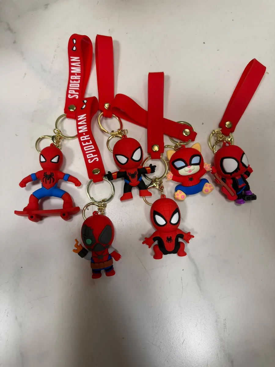 pięć breloków Spidermana z czerwonym paskiem i figurkami na białym tle