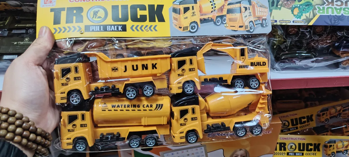 Zestaw czterech żółtych samochodów budowlanych w opakowaniu foliowym z napisem TRUCK