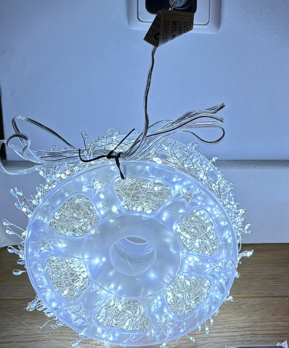 Lampki choinkowe LED na białym druciku nawinięte na przezroczystą szpulę z gwiazdkami, zimne białe światło
