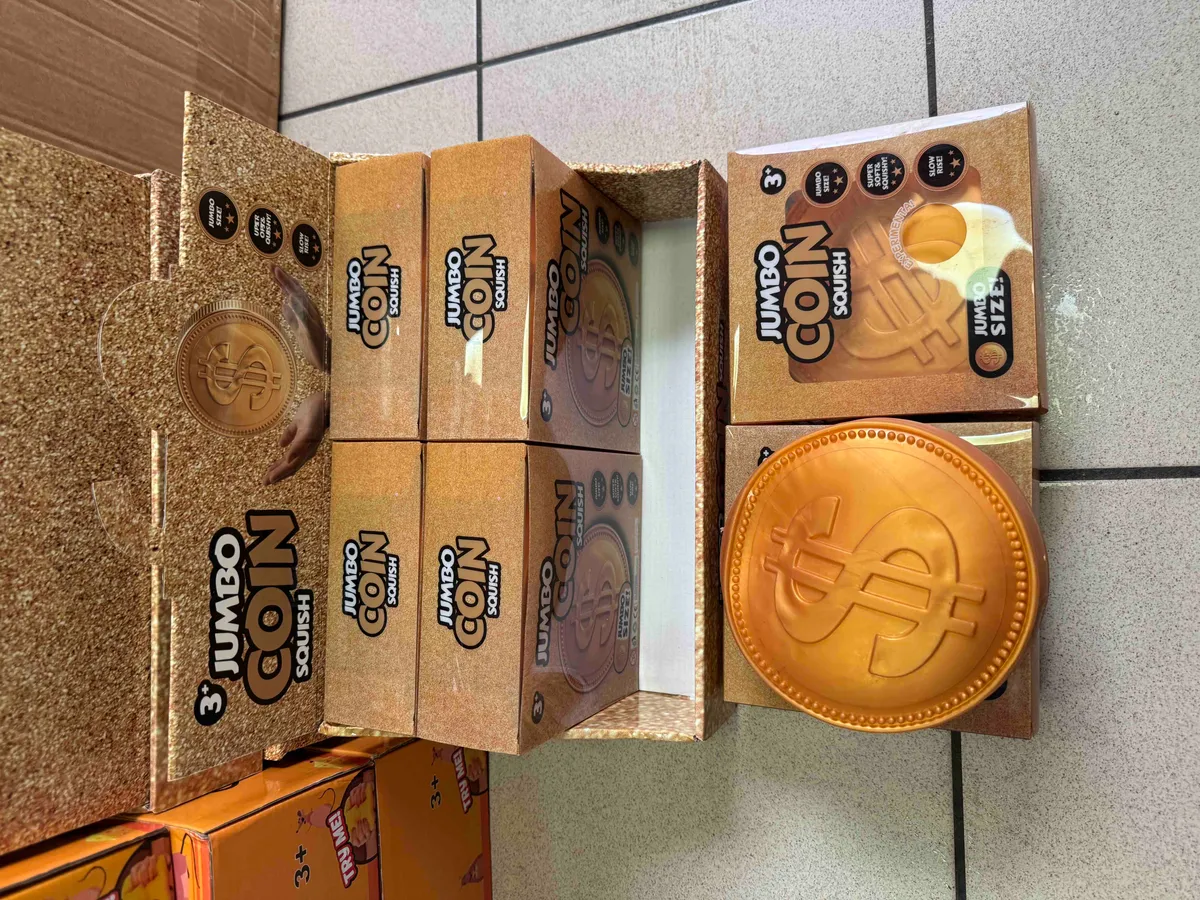 Pomarańczowa duża moneta antystresowa Jumbo Coin Squish w opakowaniu na sklepowej półce