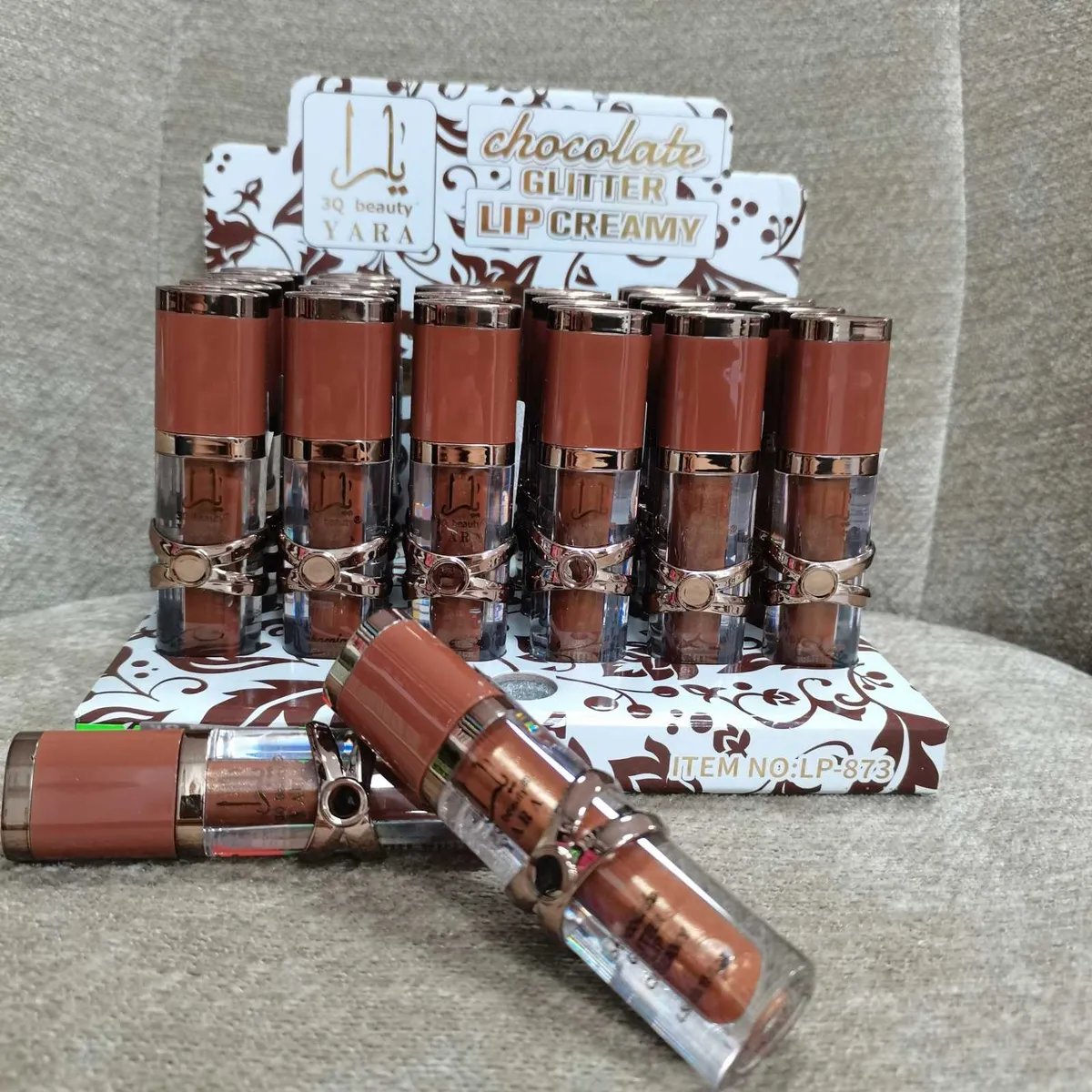 Błyszczyki do ust w brązowym kolorze z brokatem na stojaku z napisem chocolate glitter lip creamy