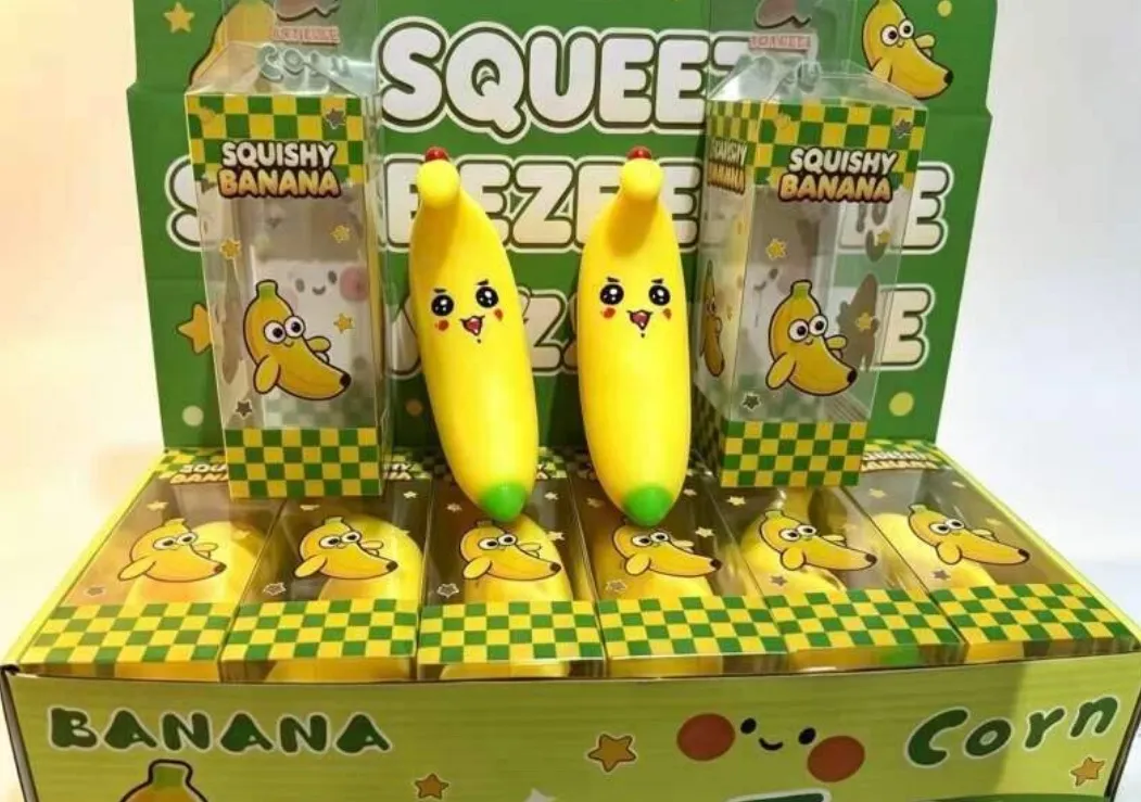 Żółta gniotka w kształcie banana z zielonym czubkiem w przezroczystym opakowaniu plastikowym