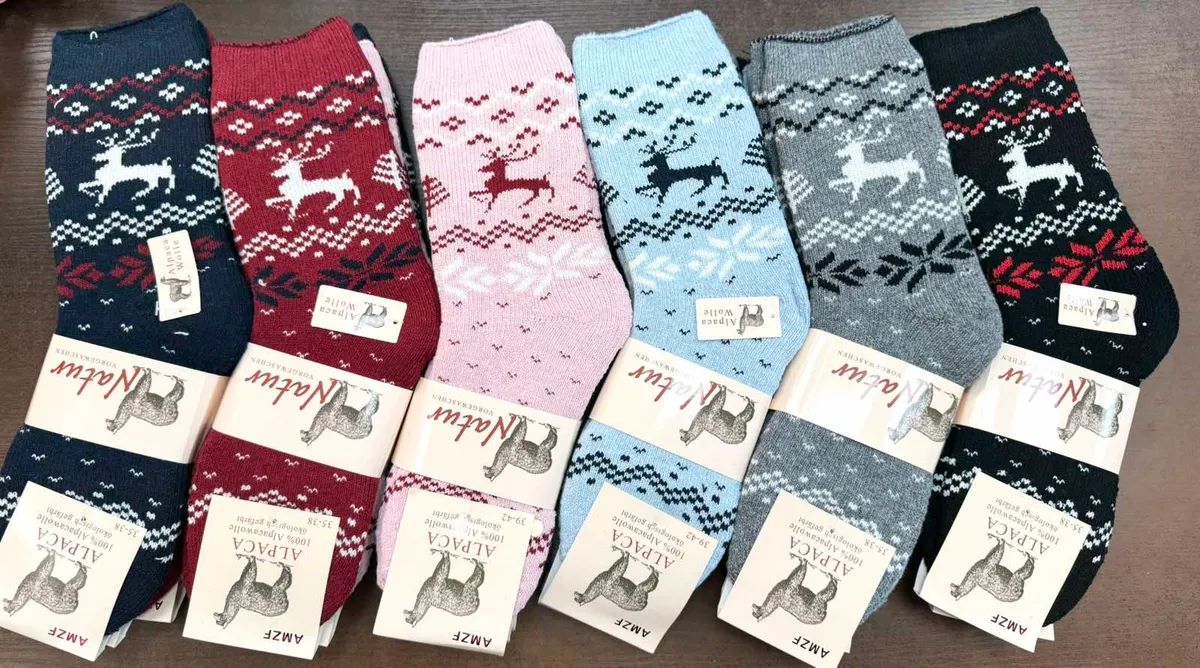 Sześć par damskich skarpetek Alpaca Wool z motywem renifera w różnych kolorach na stole