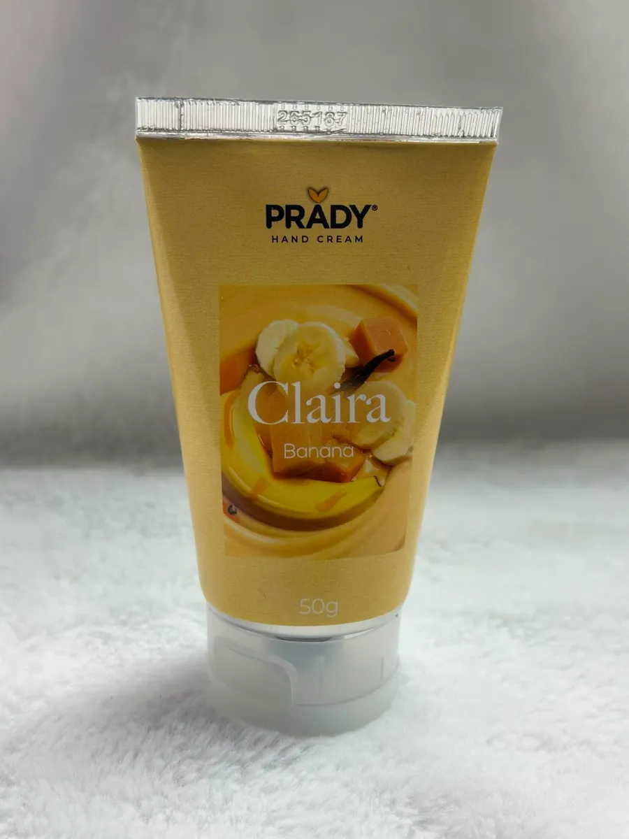Tubka kremu do rąk Prady Claira w żółtym opakowaniu z grafiką banana i przezroczystą zakrętką