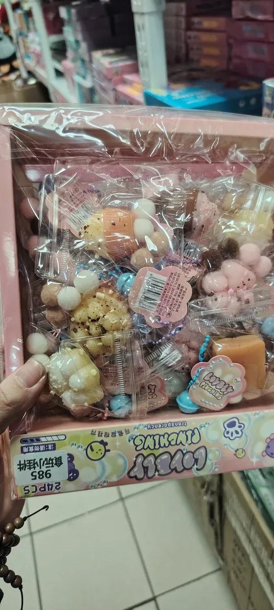 Zestaw pastelowych gniotków antystresowych w plastikowym pudełku z różowymi elementami