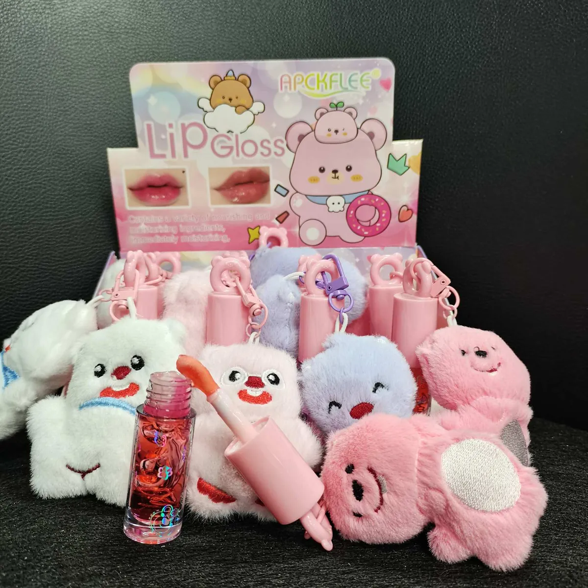 błyszczyk do ust z różowym aplikatorem i pluszowym brelokiem misia w pastelowych kolorach