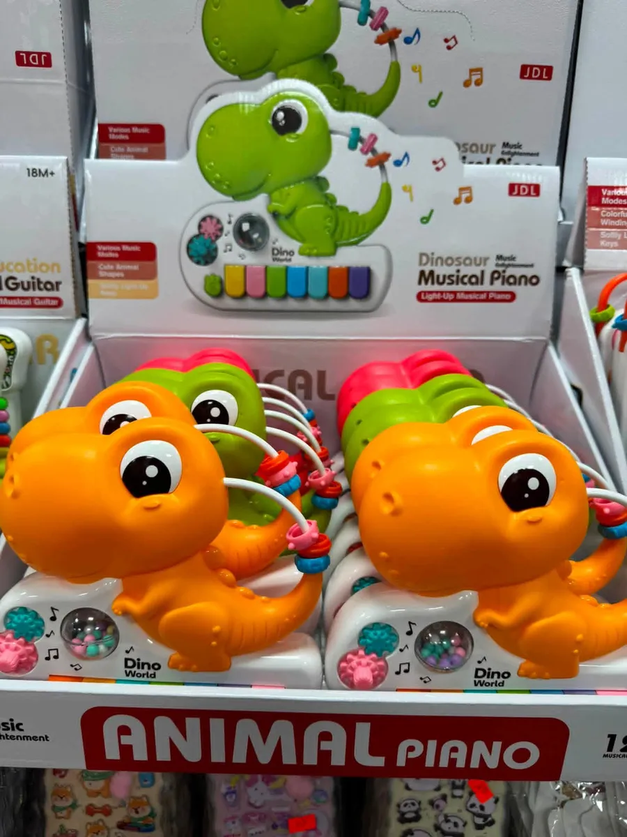 Kolorowe pianinko z motywem dinozaura w pomarańczowym i zielonym kolorze, z kolorowymi klawiszami i elementami do zabawy