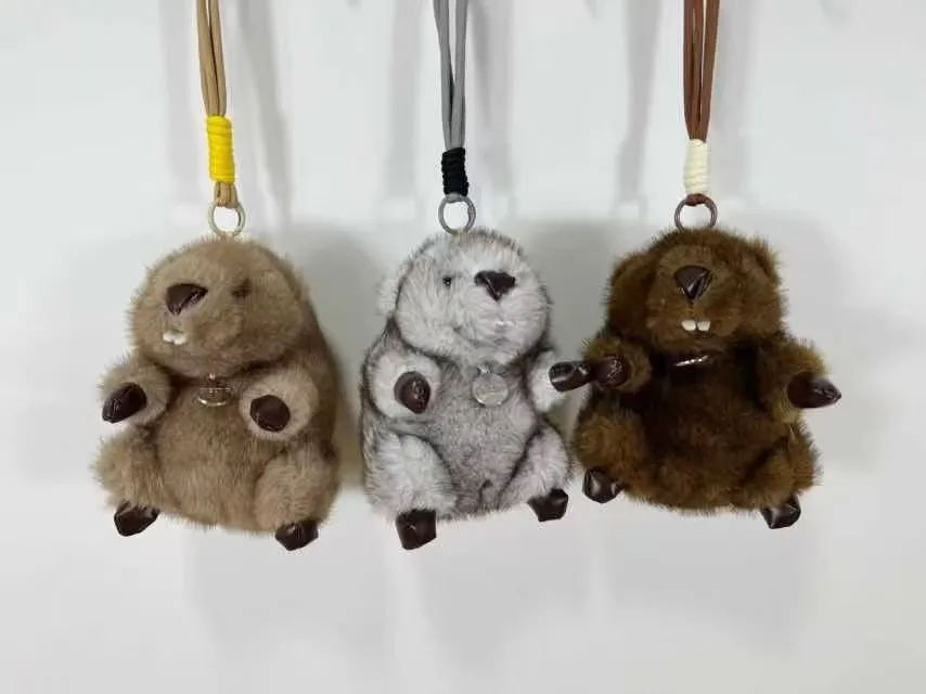Trzy pluszowe breloki 18 cm w kolorach jasnobrązowym, szarym i ciemnobrązowym z zawieszkami